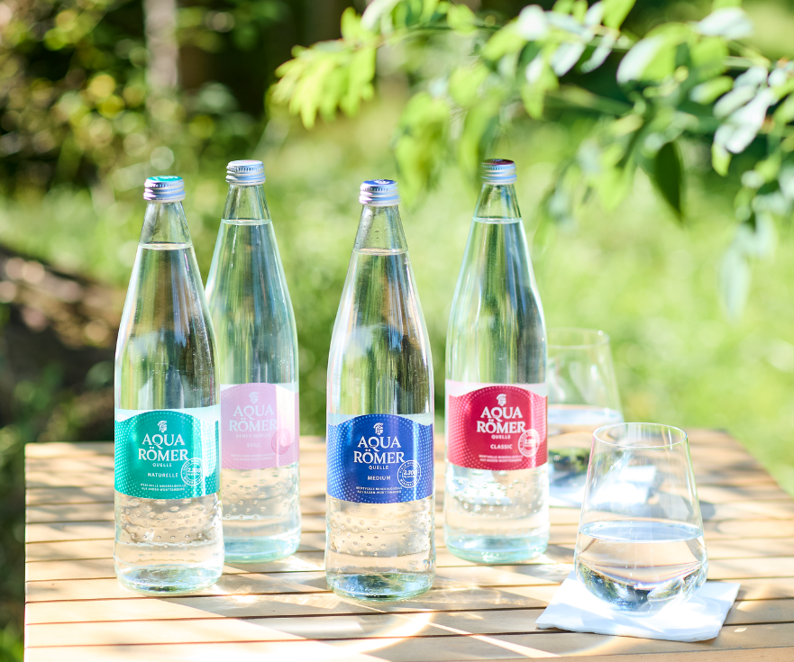 Vier Sorten Aqua Römer Mineralwasser in Glasflaschen.