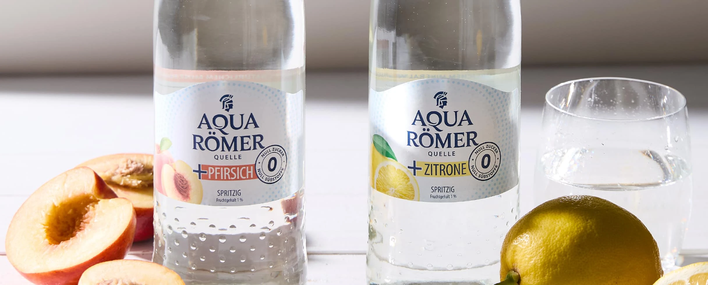Aqua Römer Plus Pfirsich und Zitrone mit frischen Früchten.